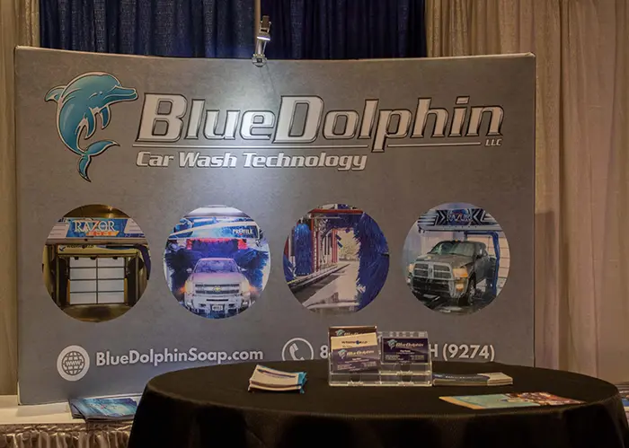 Tradeshow booth with table, and Blue Dolphin banner behind table